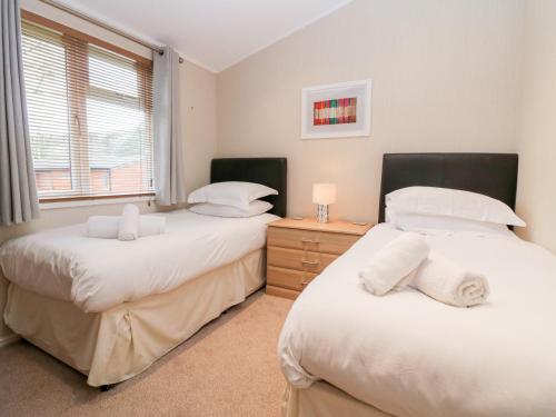 a bedroom with two beds and a window at Highfield Lodge in Windermere