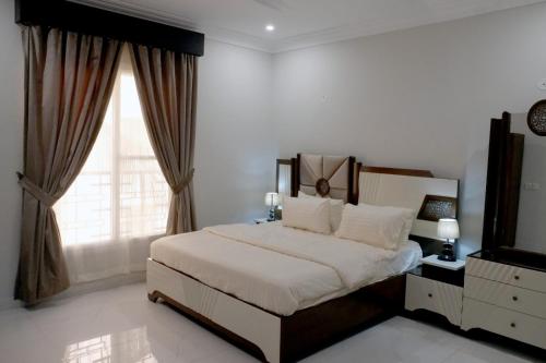een slaapkamer met een groot bed en een raam bij Al Rasheed Apartments second floor apartment in Karachi