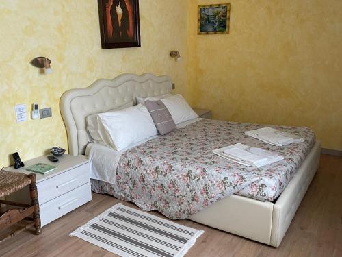 a bedroom with a bed and a nightstand with a bed sidx sidx at Hotel Diffuso Il Portichetto sulla collina a Vezio Perledo in Perledo