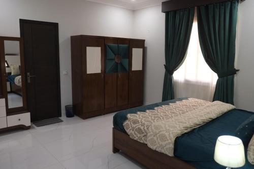 a bedroom with a bed and a cabinet and a window at Al Rasheed Apartments second floor apartment in Karachi