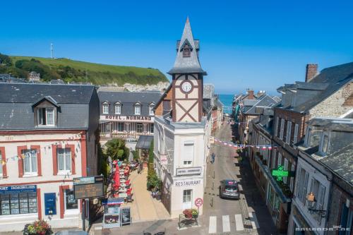 an old town with a clock tower on a street at Hôtel Normand Yport Hôtel Ambiance familiale non étoilé in Yport