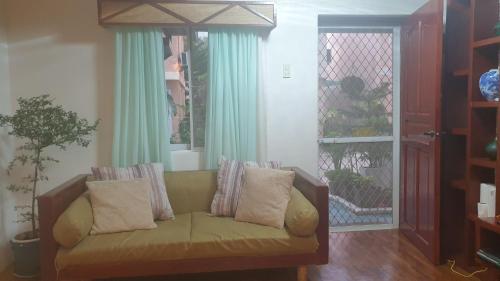 a couch with pillows sitting in a living room at Tagum Mini Hotel By Tripleview residences in Tagum