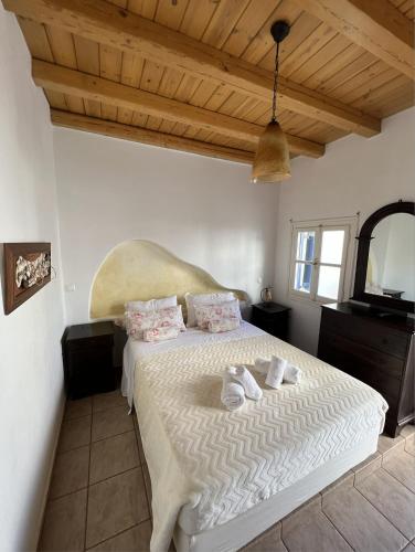 a bedroom with a large bed with white sheets and pillows at Yalos Mykonos Ornos Pouli private apartments w shared swimming pool in Mýkonos City