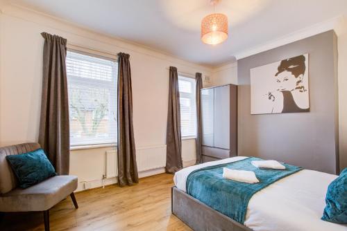 a bedroom with a bed and a chair and a window at Statera Apartments - 2-Bed House in Stratford in London