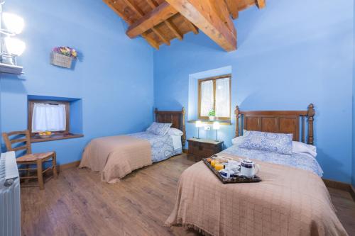 1 dormitorio con 2 camas y paredes azules en Ekolanda, en Esnoz
