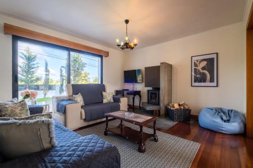 a living room with a blue couch and a table at Azores Green Woods Villa in São Vicente Ferreira