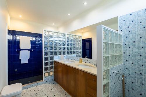 ein Bad mit einem Waschbecken, einem WC und blauen Fliesen in der Unterkunft Azores Green Woods Villa in São Vicente Ferreira