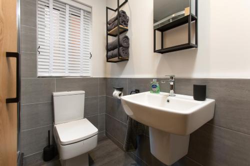 uma casa de banho com um lavatório branco e um WC. em The Duke em Trowbridge