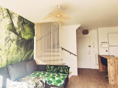 uma sala de estar com um sofá e um mural de palma em Beau duplex familial avec jardin clôturé em Douvaine