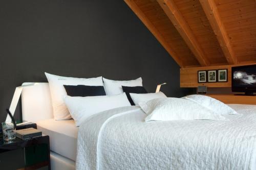 a bedroom with a bed with white sheets and pillows at Bergesgrün in Oberstdorf