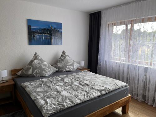 a bedroom with a bed and a large window at Ferienwohnungen Koch in Marburg an der Lahn