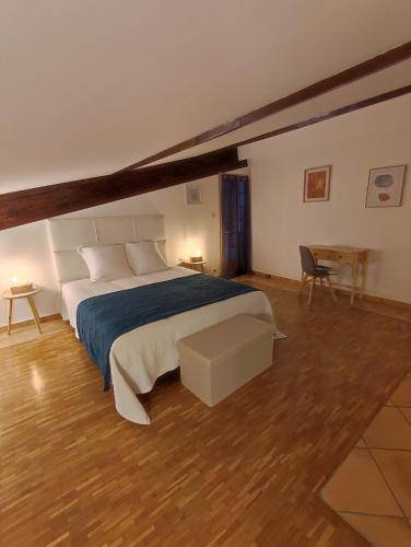 a bedroom with a large bed and a wooden floor at Lou Cantou in Nègrepelisse