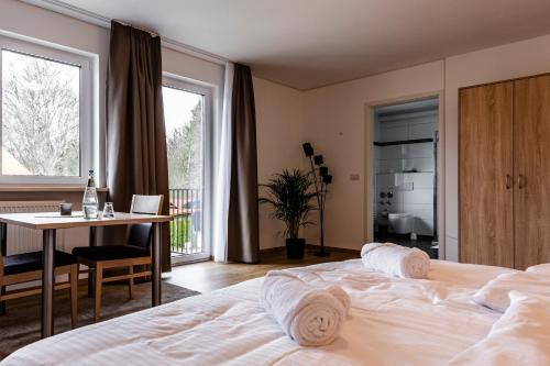 1 dormitorio con cama, escritorio y mesa en Motel Zur Dachsbaude en Wandlitz