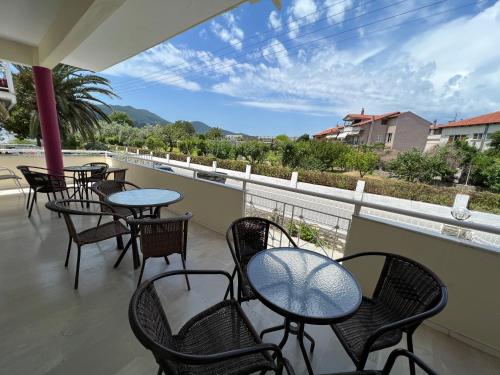 a patio with tables and chairs on a balcony at Villa Meresi - Thassos Town Center in Limenas