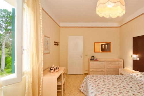 a bedroom with a bed and a desk and a window at B&B Da Pio in Pietrasanta