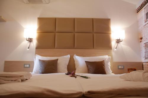 a bedroom with a large bed with white sheets and pillows at Boutique Hotel Marco Polo in Gradac
