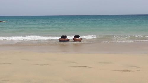 two boys are sitting in the water on the beach at Welooveyou Zafiro's in Morro del Jable