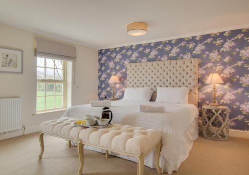 a bedroom with a large white bed with a tufted headboard at Ketlam View The Old Coach House in Pentney