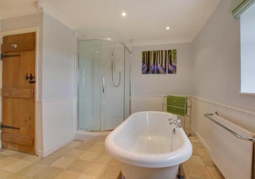 a white bathroom with a shower and a tub at Ketlam View The Old Coach House in Pentney