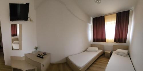 a small room with a bed and a window at Cabana Stejarul in Botoşani