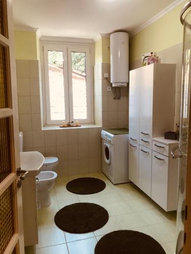 a small kitchen with a white refrigerator and a toilet at Bonaca in Izola