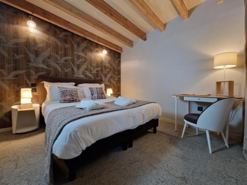 1 dormitorio con cama, escritorio y silla en Domaine de l'Epau Eco-Resort - Eco-Lodges, en Yvré-lʼÉvêque