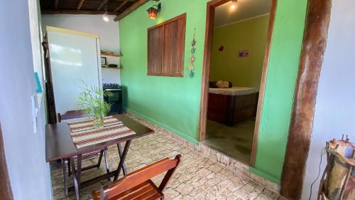 a room with a table and a green wall at CÉU DE AGARTHA Retiros e Vivências in Alto Paraíso de Goiás