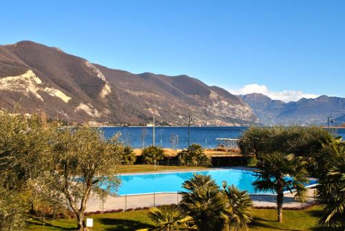a swimming pool with a view of the water and mountains at Ulivi Hotel & Residence in Paratico