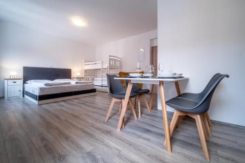 a bedroom with a bed and a table and chairs at Apartment 123-2 Lipno Home in Lipno nad Vltavou