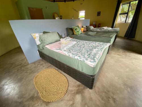 a large bed in a room with a rug at Izulu Eco Lodge in Sodwana Bay