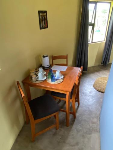 a wooden table and chairs with a tea set on it at Izulu Eco Lodge in Sodwana Bay