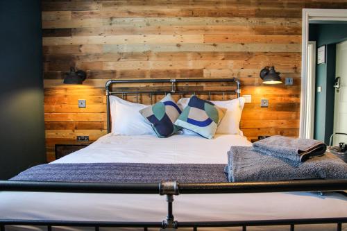 a bed in a room with a wooden wall at no 12 - Stunning Self Check-in Apartments in Worcester Centre in Worcester
