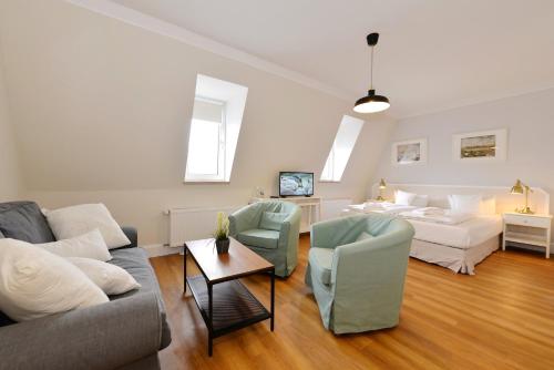 a living room with a couch and a bed at Hotel Stralsund in Stralsund