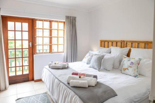 a bedroom with a large white bed with towels on it at Beachfront Accommodation in Port Alfred