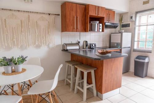 a kitchen with a counter and a table with chairs at Beachfront Accommodation in Port Alfred
