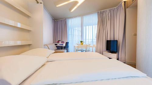 コウォブジェクにあるVacationClub UltraMarine Apartament 21のベッド2台とテレビが備わるホテルルームです。