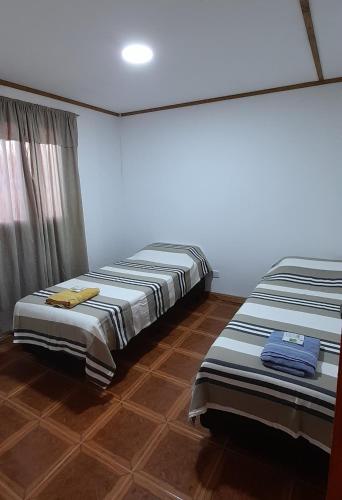 2 Betten nebeneinander in einem Zimmer in der Unterkunft M&M ll in Comodoro Rivadavia