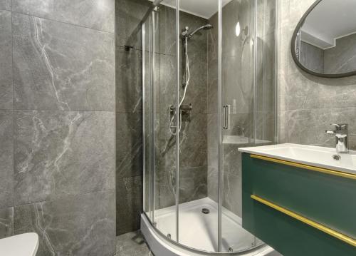 een badkamer met een douche, een toilet en een wastafel bij Mieszkanie Zacisze - NoclegiSopot in Sopot