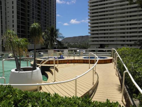 a wooden walkway leading to a pool in a city at Penthouse With Fabulous Ocean View Near Waikiki Beach in Honolulu