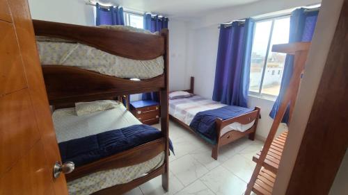 two bunk beds in a room with a window at Bravo Surf Camp Punta Rocas in Punta Negra
