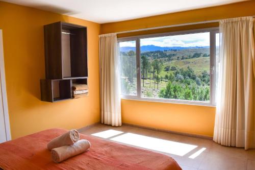 1 dormitorio con ventana grande con vistas en Ayllupelli en Villa Berna