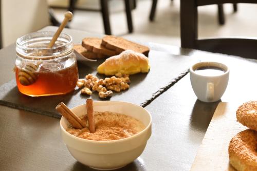 a table with a bowl of peanut butter and cinnamon sticks at Le Palace Hotel in Thessaloniki