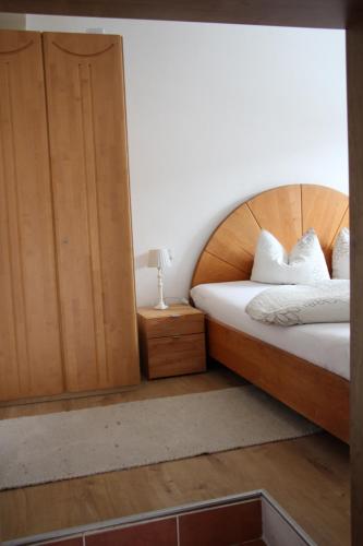 a bedroom with a bed with a wooden headboard at Klein aber fein im Herzen des Pinzgau in Piesendorf