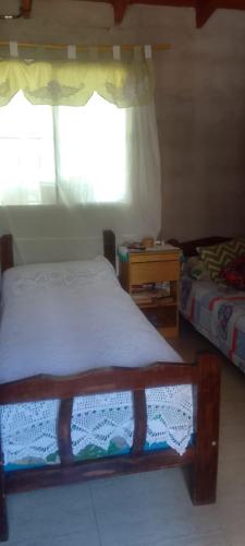 een kleine slaapkamer met een bed en een raam bij El Descanso de la Yapa in Villa Bustos