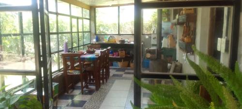 a kitchen with a table and chairs in a room with windows at El Descanso de la Yapa in Villa Bustos