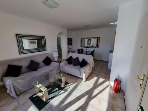 een woonkamer met 2 banken en een tafel bij South Facing Apartment, Fantastic Sea Views,Terrace, 300m beach in Mojácar