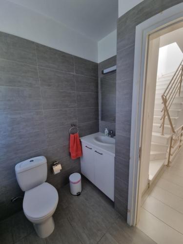 a bathroom with a toilet and a sink and a staircase at Coral Blue Bay Villa in Coral Bay