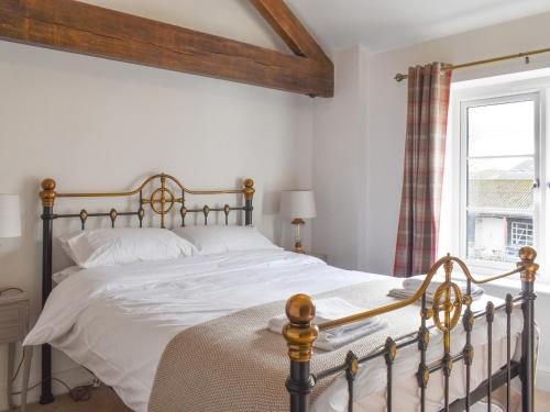 a bedroom with a bed with white sheets and a window at Apple Tree Barn- Uk40791 in Church Minshull