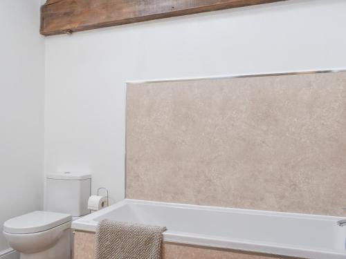 a bathroom with a toilet and a bath tub at Apple Tree Barn- Uk40791 in Church Minshull