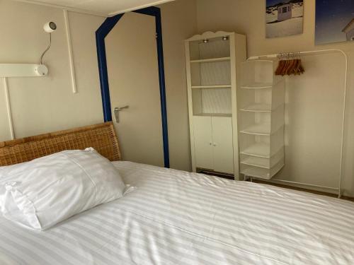 a bedroom with a bed with a pillow and a closet at RB Hostel in Zierikzee